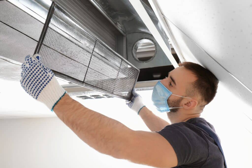 Man putting cover back on extractor fan